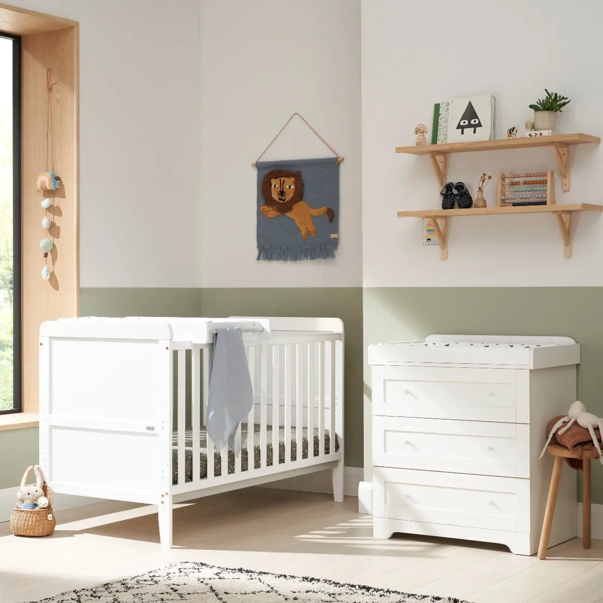 white Crib and small cabinet with a changing area